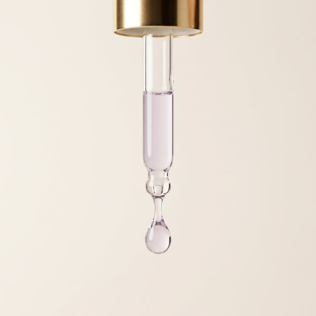 Pipeta dourada com uma gota de sérum Memoria quase transparente e de tom lilás muito suave.